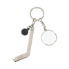 A metal key ring with a puck and a hockey stick for sublimation